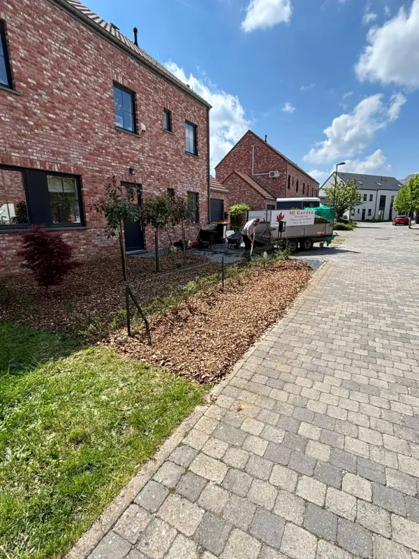 Jardin de façade fraîchement planté et paillé, remorque MJ Garden à l'arrière